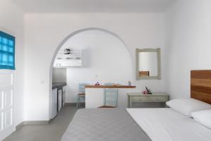 Un dormitorio blanco con una cama y una mesa. en Firoa Studios, en Donoussa