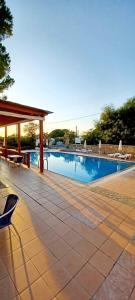 a swimming pool with a table and a chair at Pefkos Filoxenia in Pefki