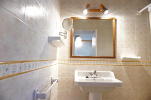 un baño con lavabo y espejo en Apartments Campanitx - Astbury Formentera, en Es Caló 28 fotos más