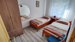 a small room with two beds and a mirror at Apartment Tina Gračac in Gračac