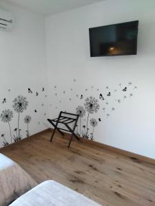 a bedroom with dandelions and butterflies on the wall at Il posto al sole in Teglio