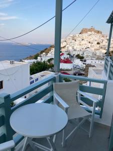 a balcony with two chairs and a table and a view at Arhodiko Studios in Astypalaia Town