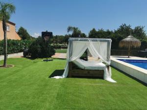 a canopy bed in a yard next to a pool at Villa Casa Segunda in Lliria