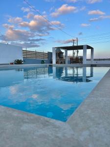 a swimming pool with blue water in front of a building at Onar Luxury Villa - Adults Only in Lachania