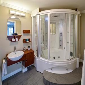 a bathroom with a shower and a sink at Above the Beach Guest Suites in Penticton