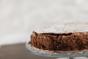 um bolo de chocolate sentado em cima de um prato de vidro em Aether Boutique Stay em Glastros