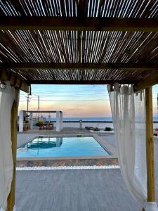 a view of a swimming pool under a wooden pergola at Onar Luxury Villa - Adults Only in Lachania