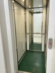 a glass shower with a green floor in a bathroom at Central Modern Apartment Bari in Bari