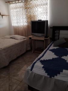 sypialnia z łóżkiem i telewizorem na stole w obiekcie Chacara Oliva w mieście Piracicaba