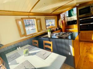 a kitchen with a table and a counter with a stove at Lovely 2-Bedroom Barge Brunswick Dock Liverpool! in Liverpool