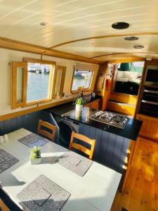 une cuisine avec une table et des chaises dans un bateau dans l'établissement Lovely 2-Bedroom Barge Brunswick Dock Liverpool!, à Liverpool