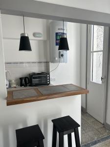 una cocina con 2 taburetes y una barra con microondas en CASI EN CASA, en Lincoln 5 fotos más