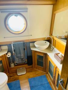Lovely 2-Bedroom Barge Brunswick Dock Liverpool! في ليفربول: حمام صغير مع حوض ومرآة