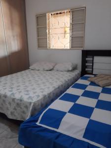 sypialnia z 2 łóżkami i oknem w obiekcie Chacara Oliva w mieście Piracicaba