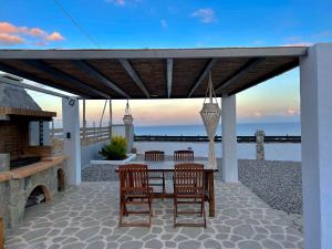 a patio with a table and chairs and a pier at Onar Luxury Villa - Adults Only in Lachania