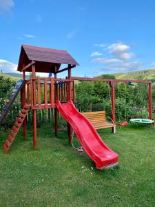 un parque infantil con tobogán y columpio en Apartmán Karovi en Deštné v Orlických horách