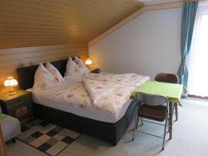 1 dormitorio con cama con almohadas y mesa en Haus Elena en Lainach