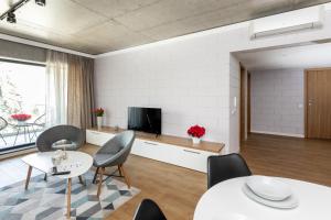 a living room with tables and chairs and a tv at River Side Residence nr 7 in Oświęcim