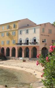 a building on the beach next to the water at Hotel de la Plage Santa Vittoria in Algajola