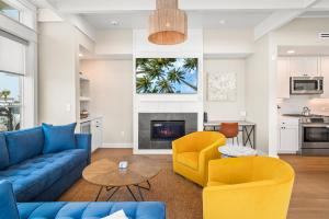 a living room with blue and yellow furniture and a fireplace at Coastal luxury steps from the shore and resort amenities in Port Aransas