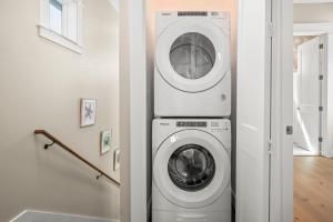 a washer and dryer in a white room at Coastal luxury steps from the shore and resort amenities in Port Aransas
