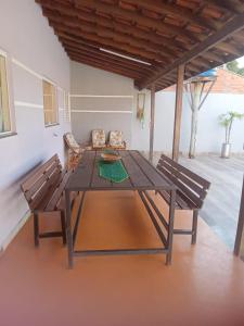 uma mesa de madeira e duas cadeiras num quarto em Chacara Oliva em Piracicaba
