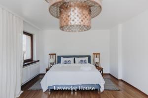 a bedroom with a bed and a large chandelier at Lavender House in Osieki