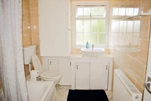 ein Bad mit einem WC, einem Waschbecken und einem Fenster in der Unterkunft The Hathway Walk Home in Bristol
