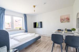 une chambre avec un lit, une table et des chaises dans l'établissement 2-Zimmer-Wohnung in Meeresnähe, à Neustadt in Holstein