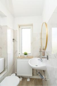 une salle de bain blanche avec un lavabo et un miroir dans l'établissement 2-Zimmer-Wohnung in Meeresnähe, à Neustadt in Holstein 26 autres photos