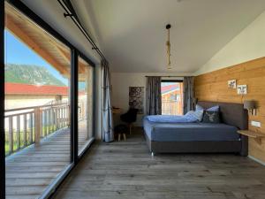 a bedroom with a bed and a balcony at Chalet Charivari Inzell mit Whirlpool, Sauna & Garten in Inzell