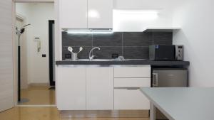 Una cocina blanca con fregadero y microondas. en Suite in Center, en Palermo