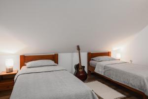 a bedroom with two beds and a guitar in it at Apartment Mia in Slunj