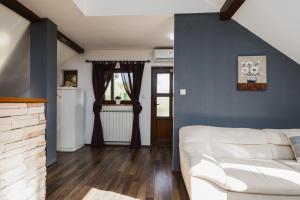 a living room with a white couch and a blue wall at Apartment Mia in Slunj