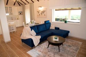 a living room with a blue couch and a table at Guest House Blažević in Tucilača