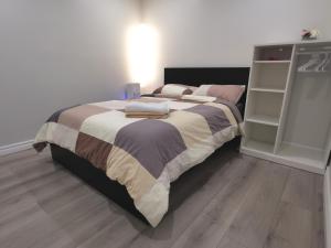 een slaapkamer met een groot bed met kussens erop bij Perfect location comfort private house lower level 2 bedroom unit in Mississauga