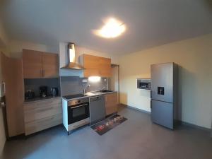 eine Küche mit Küchengeräten aus Edelstahl in einem Zimmer in der Unterkunft Maison T3 70M2 avec jardin in Lattes