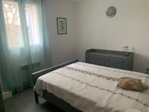 ein Schlafzimmer mit einem Bett, einer Kommode und einem Fenster in der Unterkunft Maison T3 70M2 avec jardin in Lattes
