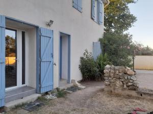 ein Haus mit blauen Türen und einem Haufen Steine in der Unterkunft Maison T3 70M2 avec jardin in Lattes
