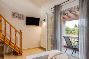 a bedroom with a sliding glass door leading to a balcony at Riposo Studios & Apartments in Kavos
