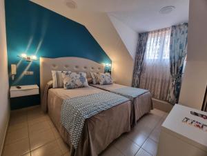 a bedroom with a bed and a blue wall at Hostal Sainz in Riaño