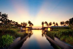 widok na rzekę z palmami o zachodzie słońca w obiekcie JW Marriott Khao Lak Resort Suites w mieście Khao Lak