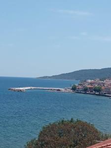 Une grande masse d'eau avec une ville en arrière-plan dans l'établissement Dora's house, à Katarráktis