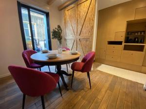 サン・トゥアンにあるL'audonière, aux portes de Parisのダイニングルーム(テーブル、赤い椅子付)