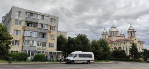 a white van parked in a parking lot next to a building at Zoldrebi apartment in Turda