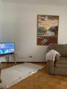 sala de estar con sofá y TV de pantalla plana en El 10 de Telmo en Buenos Aires