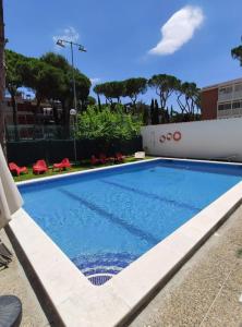 a swimming pool with blue water in a building at Chelor in Castelldefels