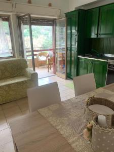 cocina y sala de estar con mesa y sillas en Appartamento Albatros fronte spiaggia, en SantʼAlessio Siculo