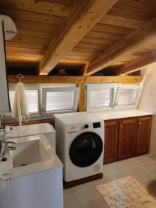 eine Küche mit einer Waschmaschine und einem Waschbecken in der Unterkunft Seafront apartment Marina2 in Jelsa