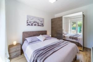a bedroom with a large bed and a mirror at Anda - Kuća za odmor in Milna